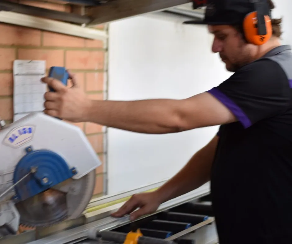 Classic Security technician cutting a frame with a workshop saw